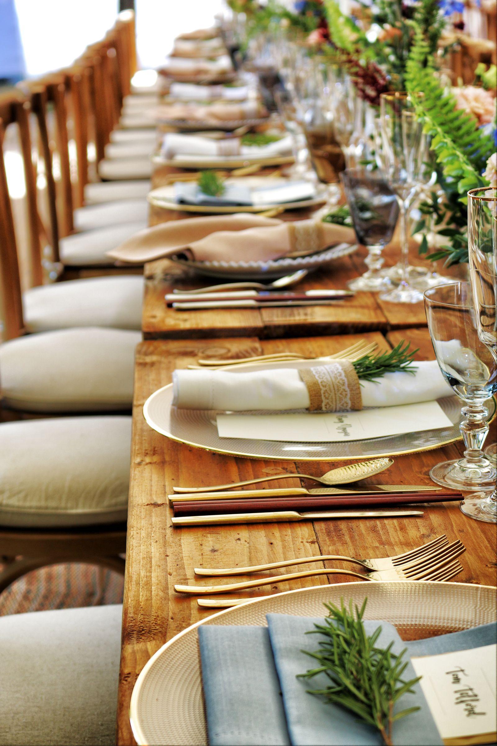 Long wooden table styled with linen and greenery